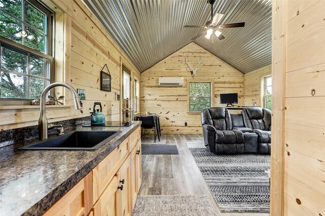 11700 Rim Rock Trl, Austin, TX 78737 - kitchen featuring dark countertops, wood finished floors, vaulted ceiling, wood walls, and a wall mounted air conditioner