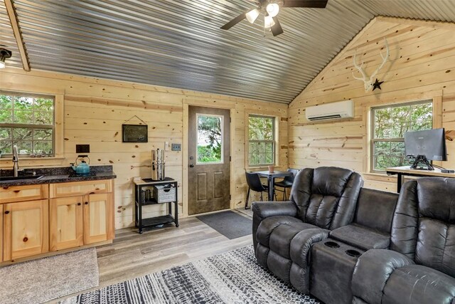 11700 Rim Rock Trl, Austin, TX 78737 - living room with a wall mounted air conditioner, lofted ceiling, ceiling fan, wood walls, and light wood finished floors