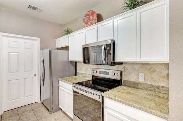 1003 E 3rd St, Georgetown, TX 78626 - kitchen featuring stainless steel appliances, backsplash, and white cabinets