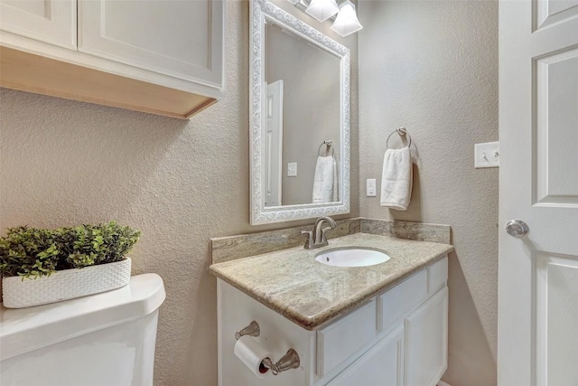1003 E 3rd St, Georgetown, TX 78626 - bathroom with toilet, vanity, and a textured wall