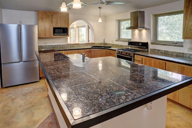 123 Konahuanui Ln, Bastrop, TX 78602 - kitchen featuring appliances with stainless steel finishes, wall chimney range hood, a sink, tile countertops, and a center island