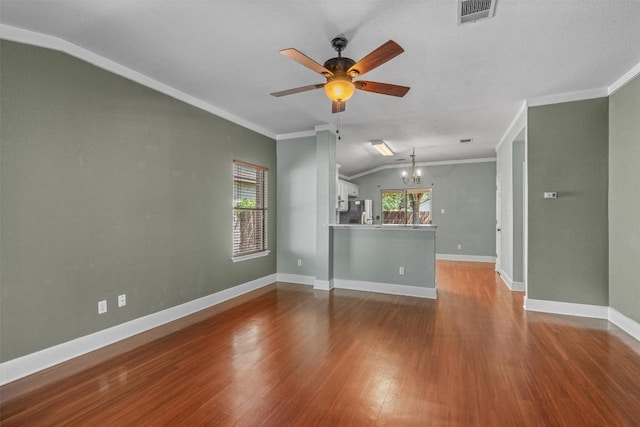 1011 Moser River Dr, Leander, TX 78641 - unfurnished living room with vaulted ceiling, a chandelier, ceiling fan, wood finished floors, and baseboards