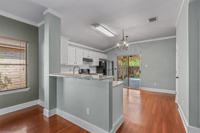 1011 Moser River Dr, Leander, TX 78641 - kitchen with black appliances, backsplash, white cabinetry, a peninsula, and ornamental molding