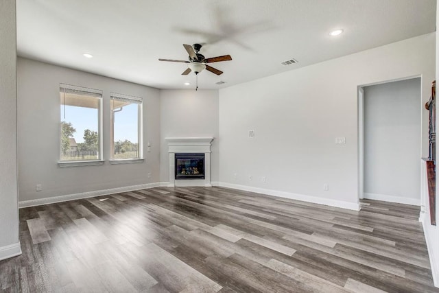 1905 Mariann Dr, Leander, TX 78641 - unfurnished living room with ceiling fan, a glass covered fireplace, wood finished floors, and recessed lighting