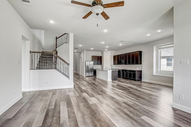 1905 Mariann Dr, Leander, TX 78641 - unfurnished living room featuring a ceiling fan, stairs, wood finished floors, and recessed lighting