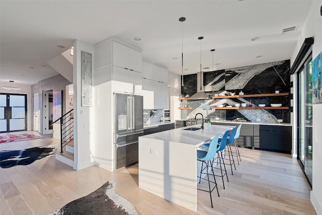 14417 Cochise Trl, Austin, TX 78734 - kitchen with high quality fridge, modern cabinets, a sink, light wood-type flooring, and a breakfast bar area