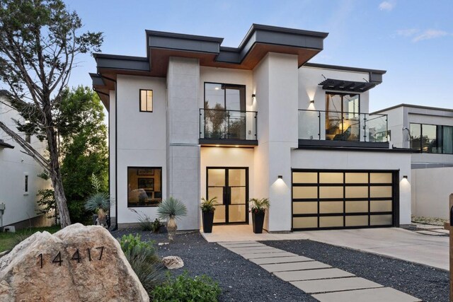 14417 Cochise Trl, Austin, TX 78734 - contemporary house featuring a balcony, stucco siding, a garage, and driveway
