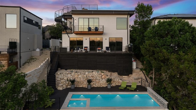 14417 Cochise Trl, Austin, TX 78734 - rear view of property with stairway, a balcony, a pool with connected hot tub, and stucco siding