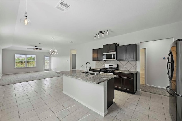 146 Blair Ct, San Marcos, TX 78666 - kitchen featuring stainless steel microwave, gas range oven, freestanding refrigerator, light tile patterned floors, and light colored carpet