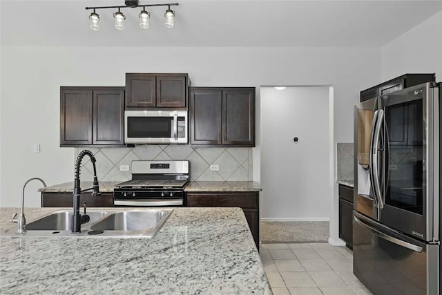 146 Blair Ct, San Marcos, TX 78666 - kitchen featuring stainless steel appliances, dark brown cabinetry, decorative backsplash, light colored carpet, and light stone counters
