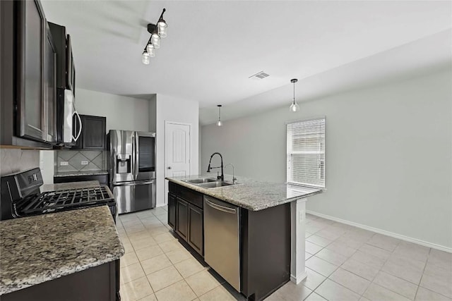 146 Blair Ct, San Marcos, TX 78666 - kitchen featuring appliances with stainless steel finishes, light tile patterned flooring, tasteful backsplash, hanging light fixtures, and a center island with sink