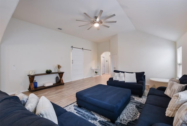 216 Walkup Ln, Leander, TX 78641 - living room with arched walkways, a ceiling fan, a barn door, vaulted ceiling, and light wood finished floors