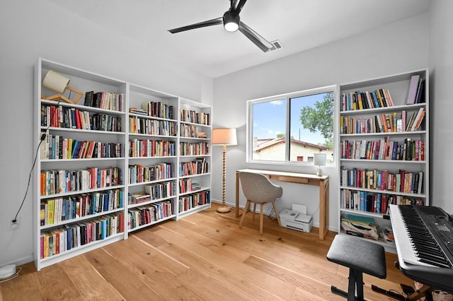 1001 Walter St Unit 2, Austin, TX 78702 - sitting room featuring bookshelves, ceiling fan, and wood finished floors