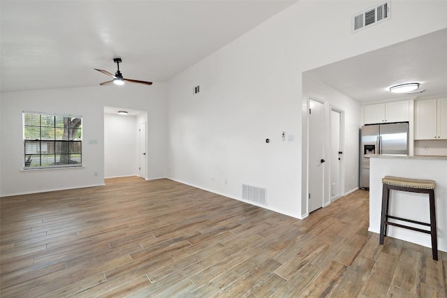 2205 Thornwild Pass, Austin, TX 78758 - unfurnished living room featuring light wood-style flooring, ceiling fan, and lofted ceiling