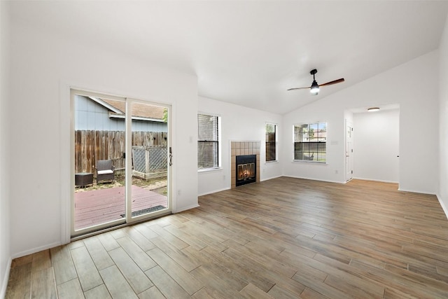 2205 Thornwild Pass, Austin, TX 78758 - unfurnished living room featuring wood finished floors, vaulted ceiling, ceiling fan, and a tile fireplace