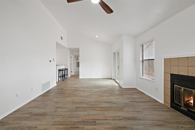 2205 Thornwild Pass, Austin, TX 78758 - unfurnished living room featuring ceiling fan, a fireplace, vaulted ceiling, and wood finished floors