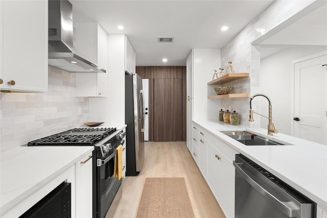 913 Spring Tree St, Round Rock, TX 78681 - kitchen with wall chimney exhaust hood, appliances with stainless steel finishes, a sink, light wood-type flooring, and decorative backsplash