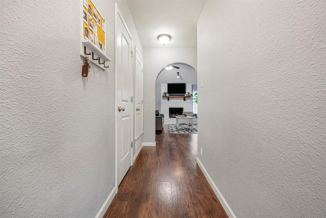 1906 Garden Villa Dr, Georgetown, TX 78628 - hallway featuring a textured wall, wood finished floors, and arched walkways