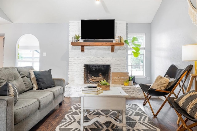 1906 Garden Villa Dr, Georgetown, TX 78628 - living area with dark wood finished floors, vaulted ceiling, a stone fireplace, and arched walkways