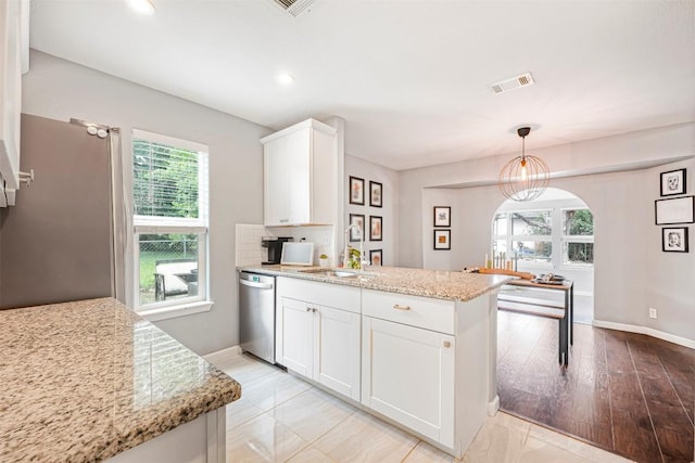 1906 Garden Villa Dr, Georgetown, TX 78628 - kitchen featuring stainless steel dishwasher, a peninsula, white cabinets, light stone counters, and decorative light fixtures