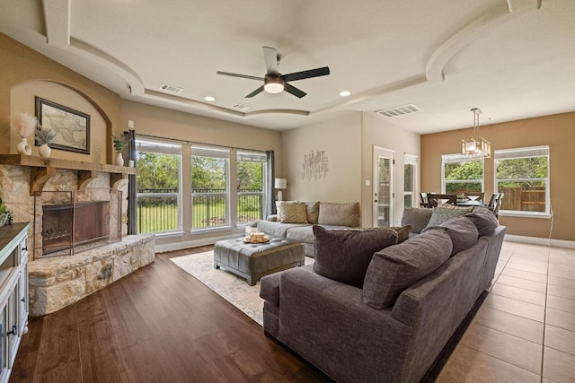 2644 Salorn Way, Round Rock, TX 78681 - living area with a tray ceiling, a stone fireplace, plenty of natural light, ceiling fan, and recessed lighting