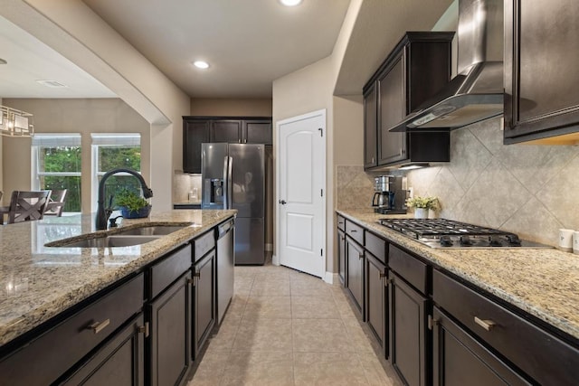 2644 Salorn Way, Round Rock, TX 78681 - kitchen with wall chimney range hood, appliances with stainless steel finishes, tasteful backsplash, light stone counters, and light tile patterned flooring