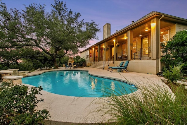 1026 Windmill Rd, Dripping Springs, TX 78620 - pool at dusk featuring a patio and an outdoor pool