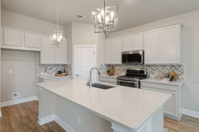 1116 Highwater Dr, Georgetown, TX 78628 - kitchen with appliances with stainless steel finishes, a sink, a chandelier, and white cabinets