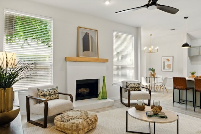 3000 Warwick Way, Austin, TX 78748 - living area featuring healthy amount of natural light, ceiling fan, a fireplace with raised hearth, and light wood-style floors