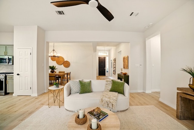 3000 Warwick Way, Austin, TX 78748 - living area with light wood-style flooring, a ceiling fan, and a chandelier