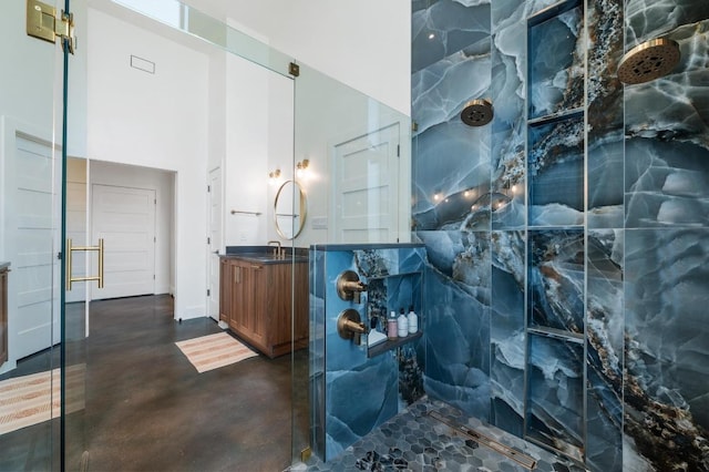 2300 Stagecoach Ranch Loop Unit B, Dripping Springs, TX 78620 - bathroom with concrete floors, a marble finish shower, vanity, and a towering ceiling