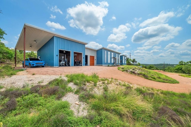 2300 Stagecoach Ranch Loop Unit B, Dripping Springs, TX 78620 - back of house featuring an outbuilding, a garage, board and batten siding, and dirt driveway