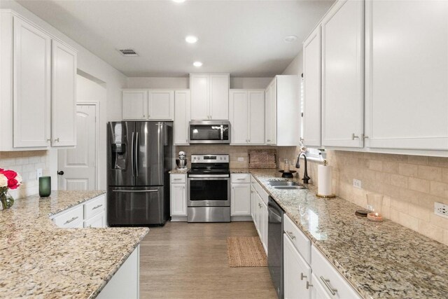 9003 Acorn Cup Dr Unit 34, Austin, TX 78748 - kitchen with appliances with stainless steel finishes, a sink, decorative backsplash, white cabinets, and recessed lighting