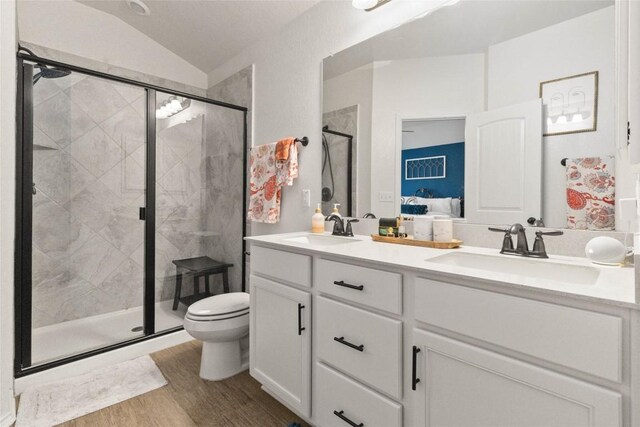 9003 Acorn Cup Dr Unit 34, Austin, TX 78748 - bathroom featuring wood finished floors, double vanity, toilet, a shower stall, and vaulted ceiling