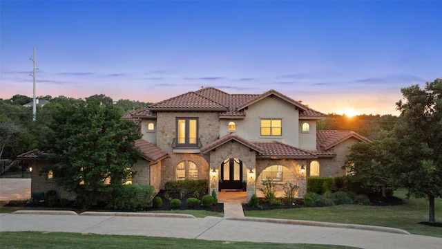 303 Bella Montagna Cir, Austin, TX 78734 - mediterranean / spanish home featuring stone siding, a tiled roof, a yard, and stucco siding