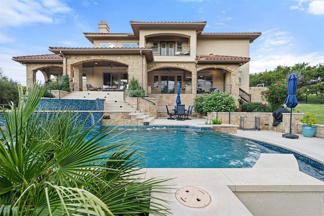 303 Bella Montagna Cir, Austin, TX 78734 - back of property featuring a patio area, stairs, stucco siding, stone siding, and a tiled roof