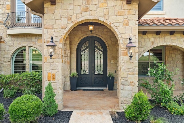 303 Bella Montagna Cir, Austin, TX 78734 - entrance to property with french doors, stone siding, and a balcony