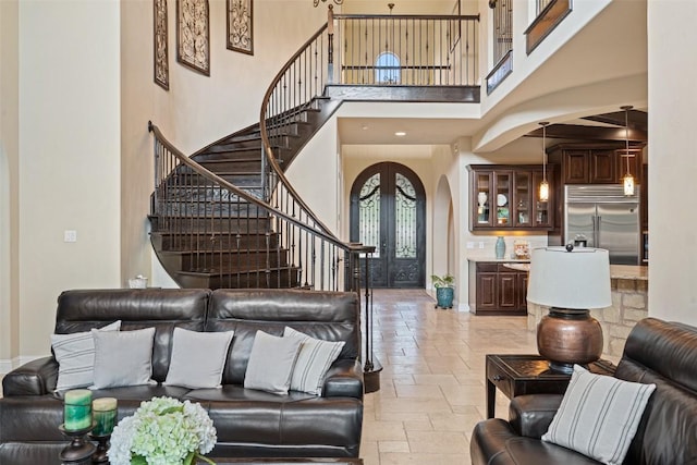 303 Bella Montagna Cir, Austin, TX 78734 - living room featuring a towering ceiling, stairs, stone tile floors, and arched walkways