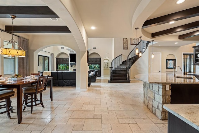 303 Bella Montagna Cir, Austin, TX 78734 - dining space featuring stone tile floors, arched walkways, stairway, beamed ceiling, and recessed lighting