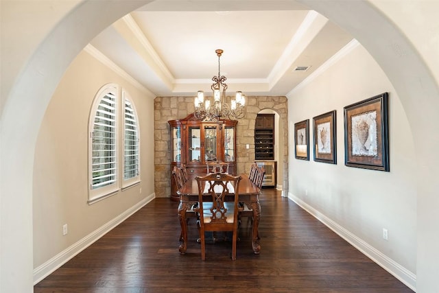 303 Bella Montagna Cir, Austin, TX 78734 - dining space with a chandelier, a raised ceiling, dark wood-style flooring, and crown molding