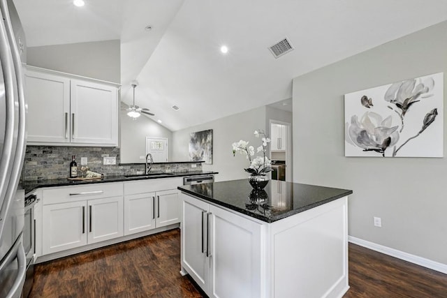 21003 Dodge Trl, Lago Vista, TX 78645 - kitchen with vaulted ceiling, freestanding refrigerator, dark wood finished floors, white cabinetry, and recessed lighting