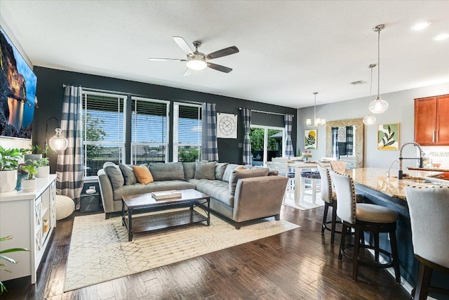 257 Culebra Dr, Georgetown, TX 78626 - living room with a chandelier, ceiling fan, and dark wood-style floors