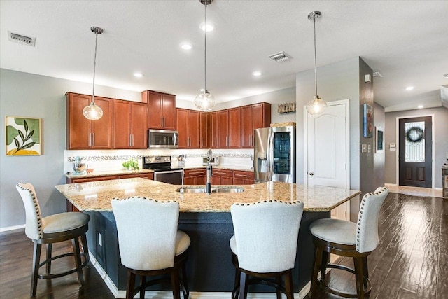 257 Culebra Dr, Georgetown, TX 78626 - kitchen with stainless steel appliances, baseboards, a sink, a kitchen island with sink, and recessed lighting