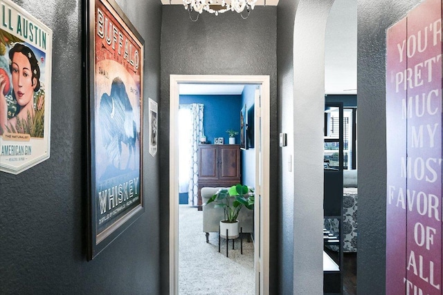 257 Culebra Dr, Georgetown, TX 78626 - corridor featuring a chandelier, a textured wall, carpet, and arched walkways