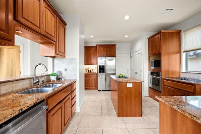 8546 Adirondack Trl Unit 14, Austin, TX 78759 - kitchen with appliances with stainless steel finishes, light stone countertops, tasteful backsplash, brown cabinets, and recessed lighting