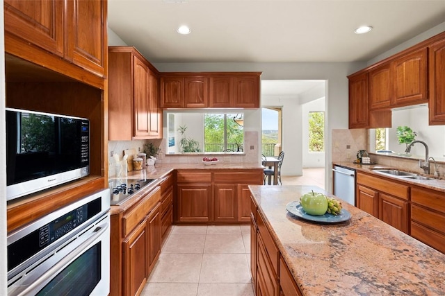 8546 Adirondack Trl Unit 14, Austin, TX 78759 - kitchen featuring stainless steel appliances, recessed lighting, backsplash, light stone counters, and brown cabinetry