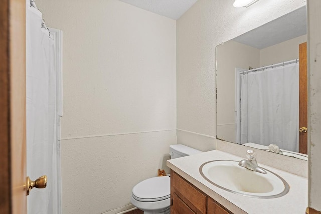 814 W Bell Ave, Rockdale, TX 76567 - bathroom featuring vanity, toilet, and a textured wall