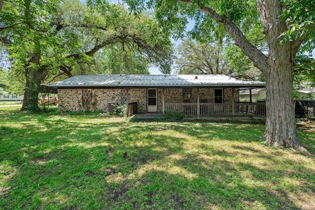 814 W Bell Ave, Rockdale, TX 76567 - rear view of property with a lawn, brick siding, and metal roof