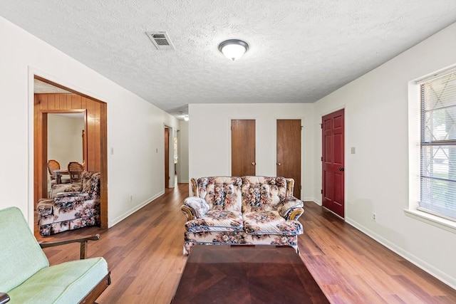 814 W Bell Ave, Rockdale, TX 76567 - living area with wood finished floors, baseboards, and a textured ceiling