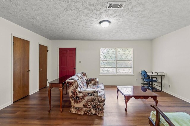 814 W Bell Ave, Rockdale, TX 76567 - living room featuring dark wood-type flooring, a textured ceiling, and baseboards